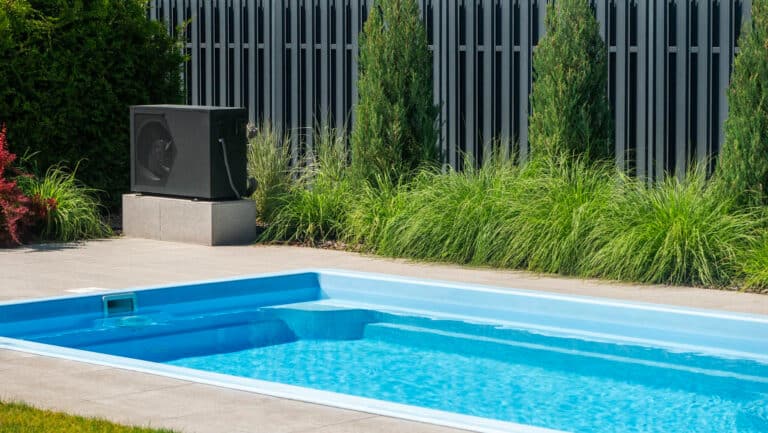 piscine enterrée avec une pompe à chaleur installée à proximité pour le chauffage de l’eau