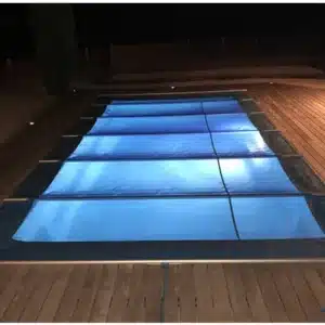 Couverture de sécurité à barres résistante au vent installée sur une piscine.