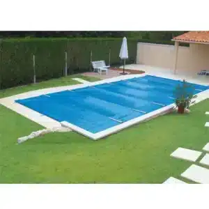 Couverture de sécurité à barres bleue installée sur une piscine extérieure.