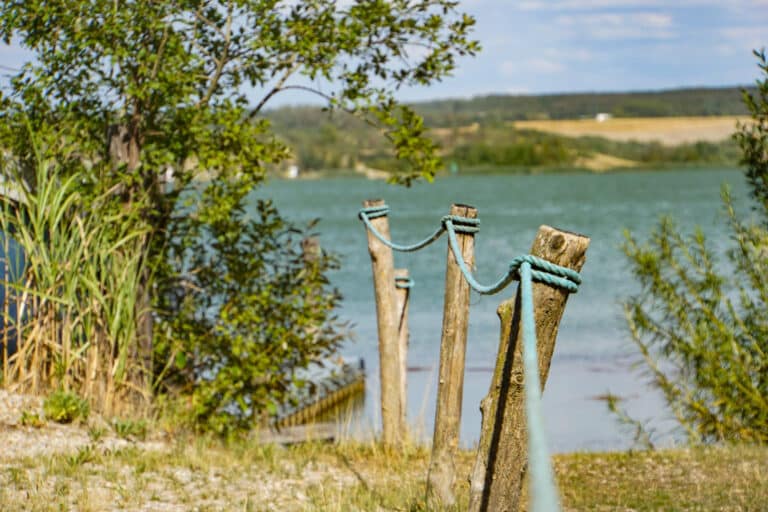 Texte alternatif : Garde-corps en bois avec une corde en bord de mer.