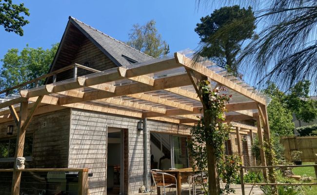 Terrasse extérieure en bois aménagée avec une pergola en bois