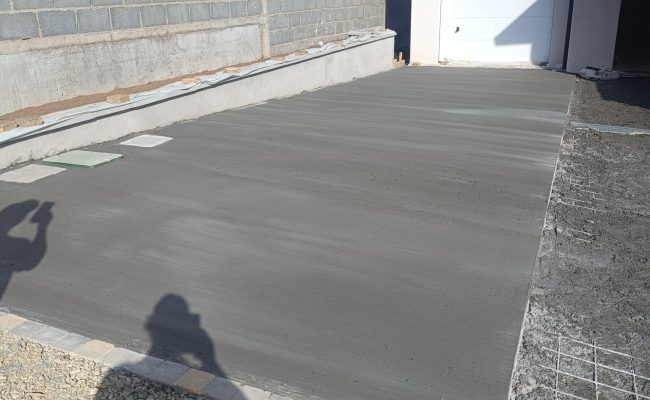 Béton brossé au sol devant un garage formant une surface résistante et antidérapante au rendu moderne