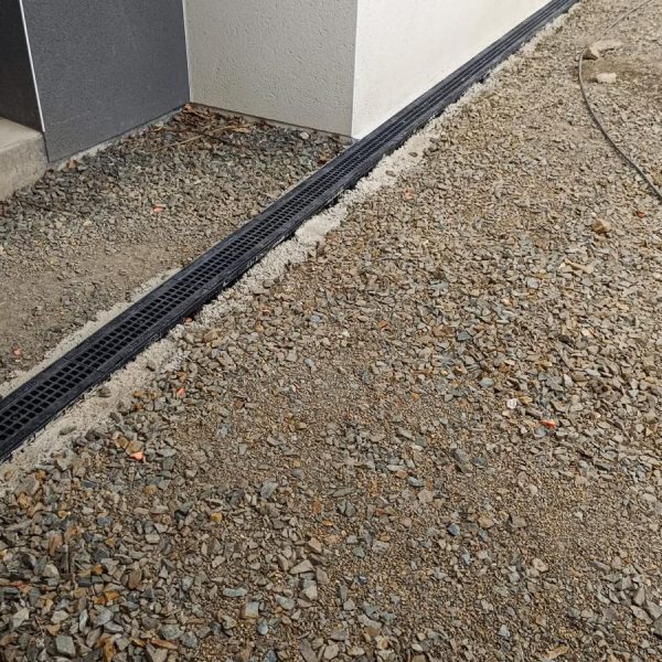 Grille d’eaux pluviales placée à l’entrée d’une maison assurant le drainage de la zone et la sécurité des accès
